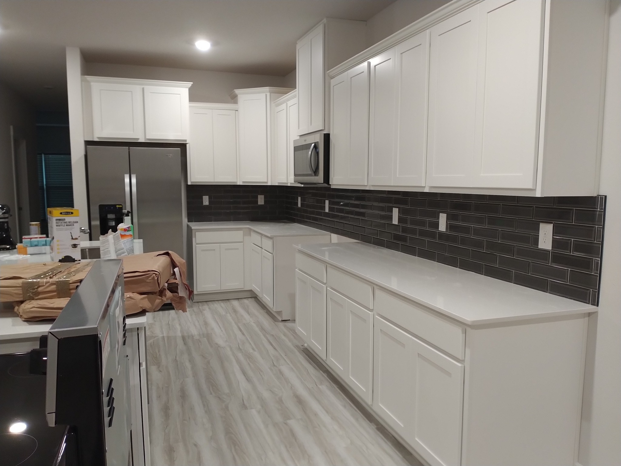 Completed kitchen with white cabinetry and new flooring