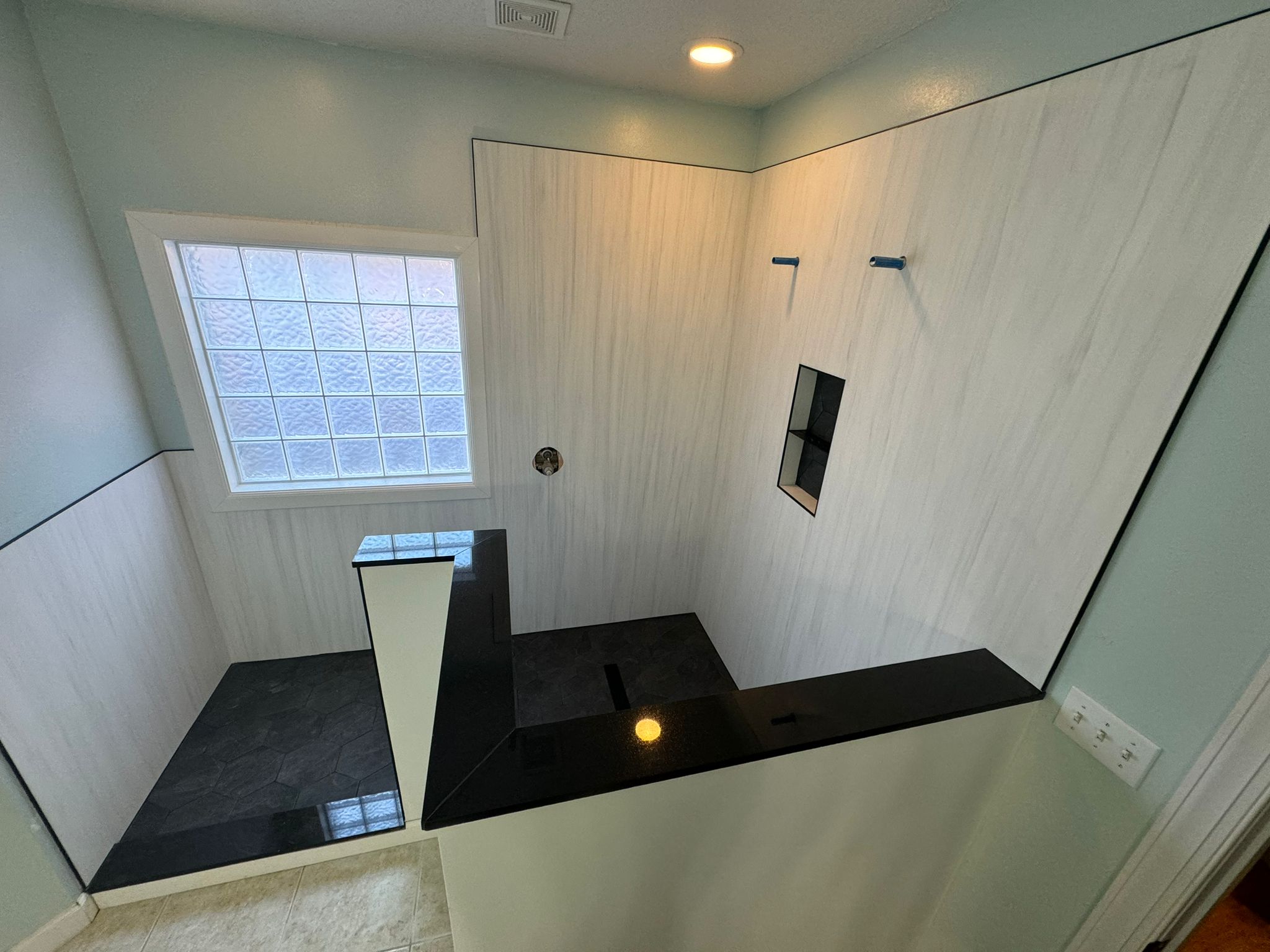 Large walk-in shower with bench and glass block window